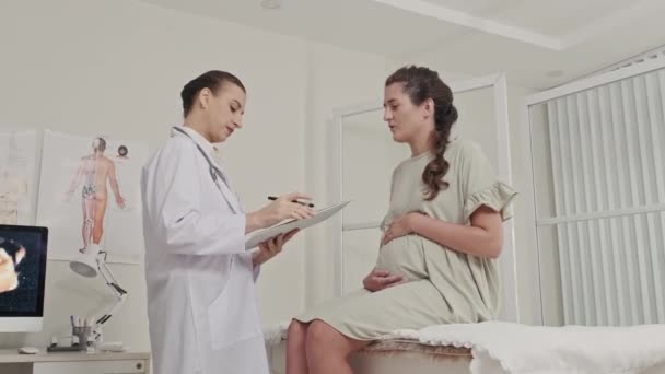 Pregnant Woman Sitting Medical Couch Prenatal Clinic Speaking Female Doctor — Video Stock