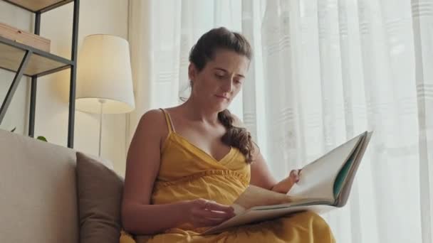 Niski Kąt Ujęcia Ciężarnej Kobiety Siedzącej Fotelu Domu Czytającej Książkę — Wideo stockowe