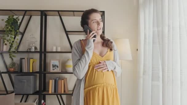 Pregnant Woman Standing Living Room Home Looking Window Speaking Mobile — 图库视频影像