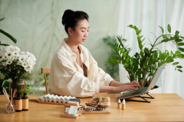 Woman filling information on products in her online shop
