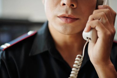 Cropped image of security officer talking on phone with manager