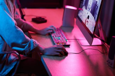Cropped image of teenage boy playing shooter videogame at home