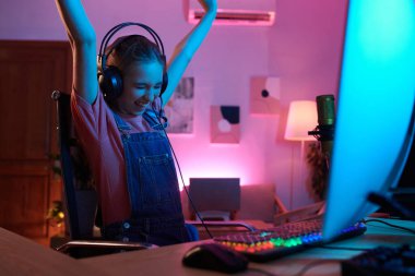 Joyful excited teenage girl celebrating winning in videogame