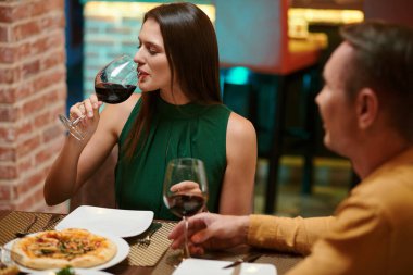 Woman enjoying good wine when having romantic dinner in restaurant