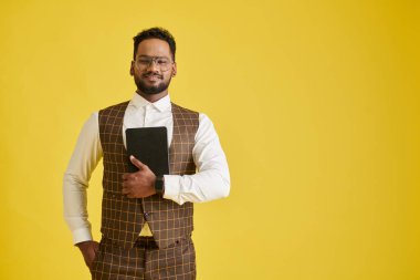 Portrait of smiling entrepreneur holding tablet computer and looking at camera