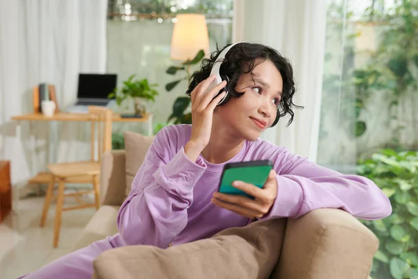 Positive Teen Girl Resting Sofa Home Listening Music Looking Window — Stok fotoğraf