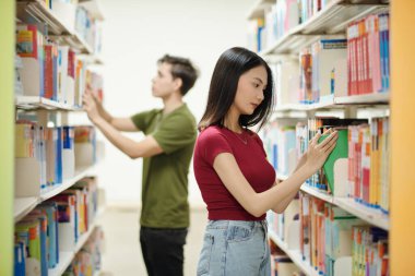 Students in school library searching for books to read after class