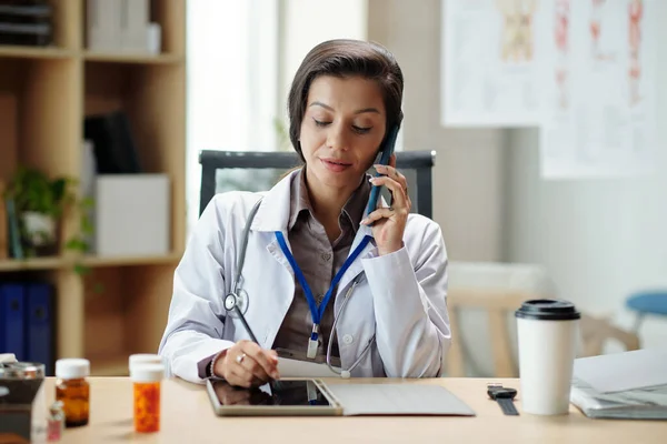 Lekarz Ogólny Rozmawia Przez Telefon Klientem Robi Notatki Formie Tablicy — Zdjęcie stockowe