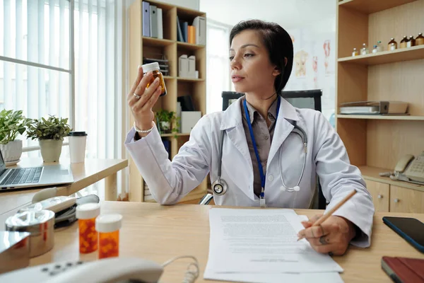 Lekarz Czyta Przeciwwskazania Opakowaniu Tabletki Przed Przepisaniem Jej Pacjentowi — Zdjęcie stockowe