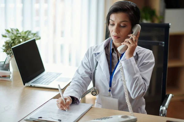 Médico Serio Hablando Por Teléfono Con Paciente Anotando Queja — Foto de Stock