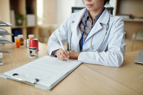 Lekarz Pracujący Biurze Podpisujący Dokumenty — Zdjęcie stockowe