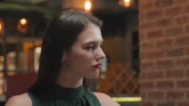 Genç bir kadının yemek yerken ve restoranda biriyle konuşurken göğsü kabarmış.