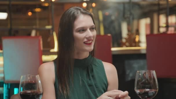 美丽的女人一边喝酒 一边笑着和男朋友聊天 一边在餐馆里吃浪漫的晚餐 — 图库视频影像