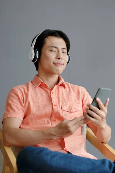 Kulaklıklı Mutlu Genç Adam Akıllı Telefondan Iyi Müzik Dinliyor — Stok fotoğraf