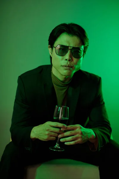 Somurtkan Asyalı Güneş Gözlüklü Adam Elinde Kırmızı Şarap Bardağıyla — Stok fotoğraf