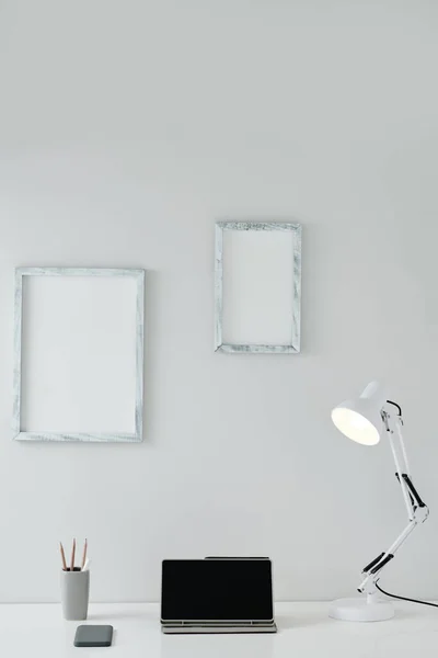 Puste Ramki Zdjęcia Ścianie Nad Biurkiem Tabletem Lampą — Zdjęcie stockowe
