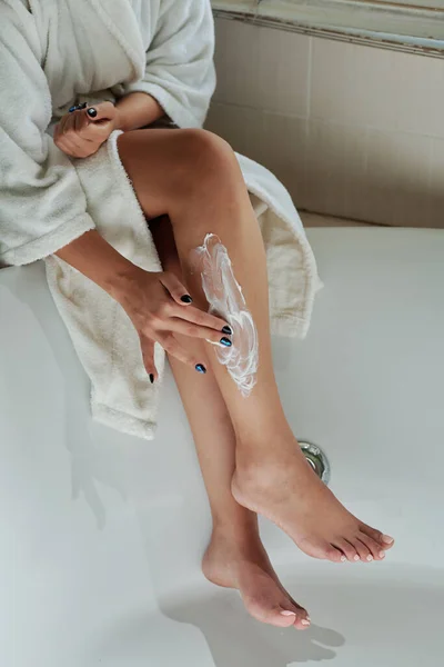 足の毛を除去するためにクリームを使用して若い女性 — ストック写真