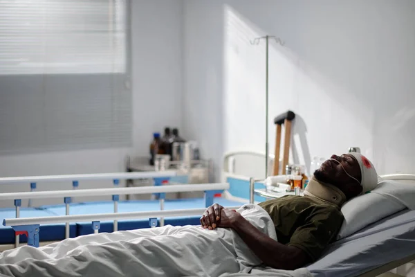 African American soldier lying on bed in military hospital after wound