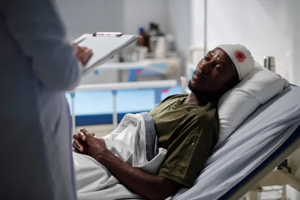 머리에 부상을 아프리카 미국인 환자가 나누면서 카드로 필기를 — 스톡 사진