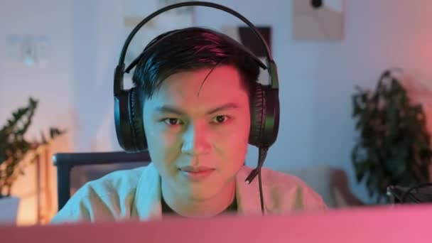 Borst Omhoog Van Opgewonden Aziatische Man Hoofdtelefoon Handelen Emotioneel Terwijl — Stockvideo