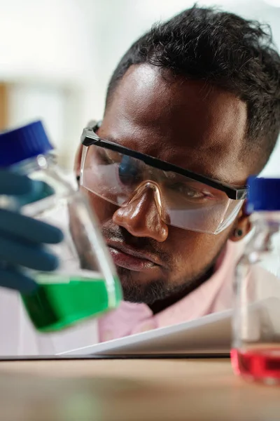 Junger Männlicher Praktikant Schutzbrille Betrachtet Während Eines Chemischen Experiments Ein — Stockfoto