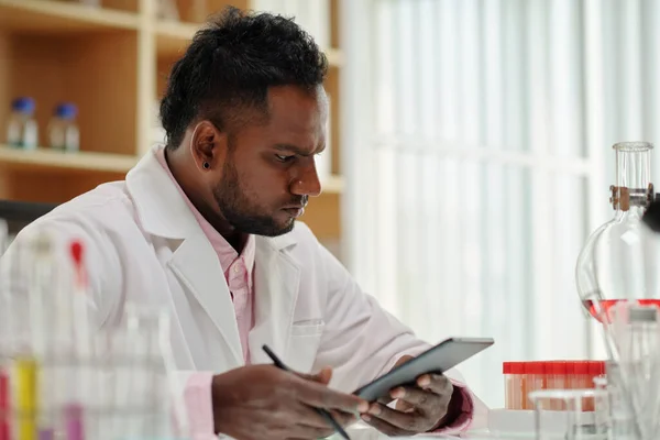 Giovane Serio Scienziato Maschio Con Tablet Guardando Campioni Sangue Fiaschette — Foto Stock