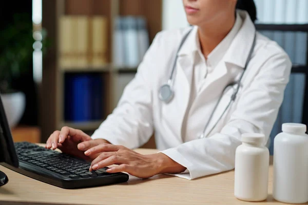在网上会诊期间 坐在电脑显示器前 在键盘上打字的年轻医生手拉手 — 图库照片