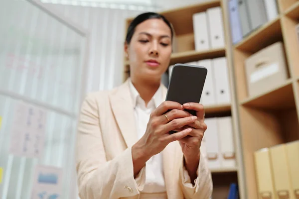 若い女性の白い襟の労働者の手は正式に携帯電話でテキストメッセージを着用するか オフィスに立っている間 ビデオチャットで通信します — ストック写真