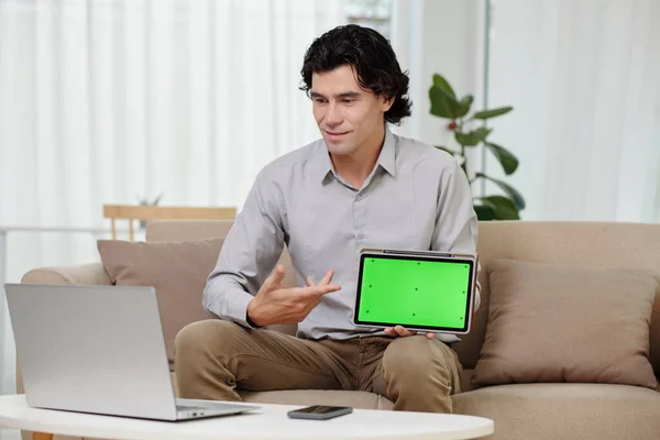 Молодой Бизнесмен Указывая Зеленый Экран Планшета Руке Глядя Экран Ноутбука — стоковое фото