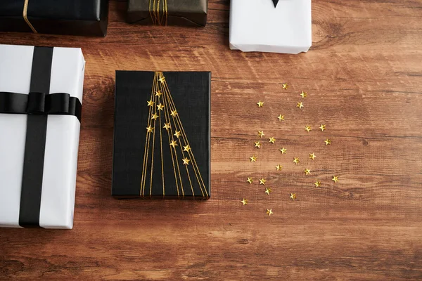 Geschmücktes Geburtstagsgeschenk Auf Dem Tisch Neben Funkelnden Klebrigen Sternen — Stockfoto