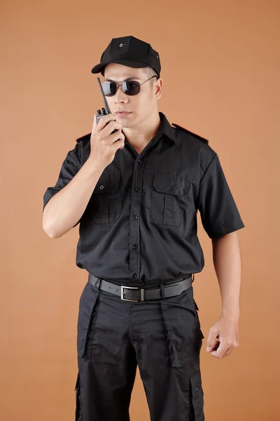 Policjant Czarnym Mundurze Czapce Okularach Przeciwsłonecznych Rozmawiający Walkie Talkie — Zdjęcie stockowe