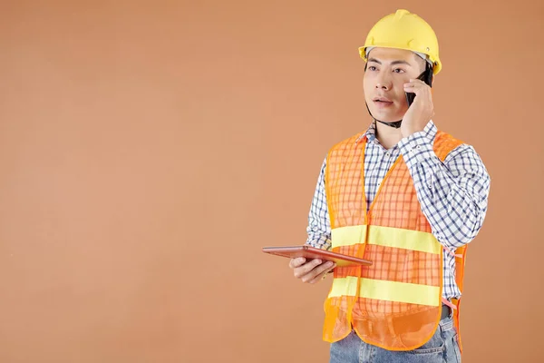 Allvarlig Byggingenjör Som Håller Surfplatta När Han Pratar Telefon Med — Stockfoto