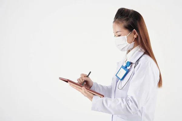 Junger Allgemeinmediziner Medizinischer Maske Füllt Krankengeschichte Des Patienten — Stockfoto