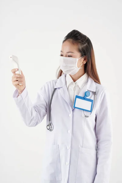 Νεαρός Ασιάτης Γιατρός Ιατρική Μάσκα Ελέγχει Θερμοκρασία Του Σώματος Ηλεκτρονικό — Φωτογραφία Αρχείου