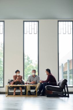 Sağlık maskeli üzgün ve yorgun iş adamları şirket iflasını veya mali krizi tartıştıktan sonra bir dakikalık saygı duruşunda bulunuyorlar.