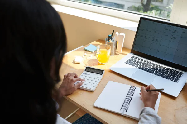 Kobieta Przedsiębiorca Sprawdzanie Planer Laptopie Dokonywania Obliczeń Podczas Pracy Domu — Zdjęcie stockowe