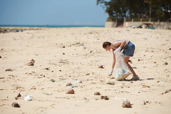 落潮后在海滩捡废品的年轻女子 — 图库照片