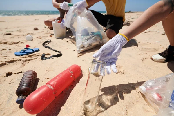 志愿人员在海滩捡玻璃和塑料垃圾的特写图像 — 图库照片