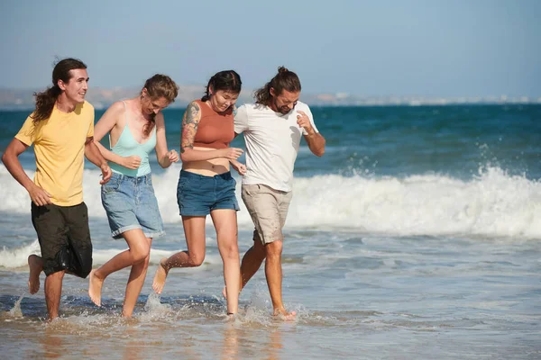 Allegro Giovani Uomini Donne Che Corrono Sulla Spiaggia Spruzzi Acqua — Foto Stock