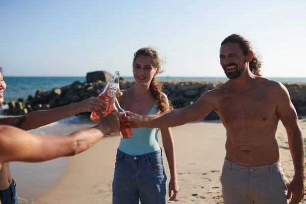 Grupa Przyjaciół Brzęczenie Szklanych Butelek Orzeźwiającym Napojem Podczas Zabawy Plaży — Zdjęcie stockowe