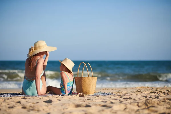 Matka Córeczka Słomkowych Kapeluszach Siedzą Plaży Rozmawiają Opalają Się — Zdjęcie stockowe