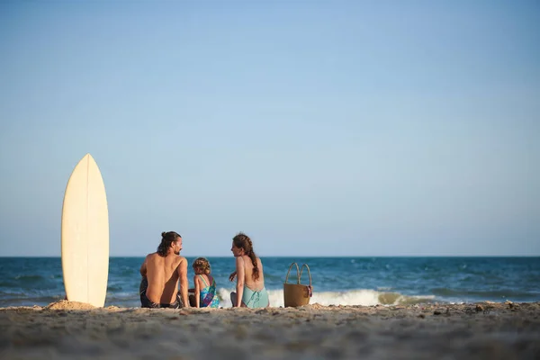 サーフィンの後 親と娘は海のビーチで休んでいます — ストック写真