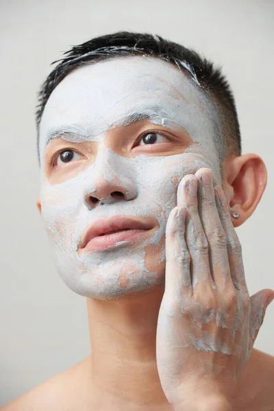 Vážný Mladý Muž Jemně Otírá Suchou Detoxikační Hliněnou Masku Obličeje — Stock fotografie