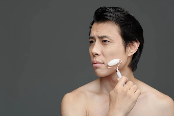 Franzindo Ásia Homem Massagem Rosto Com Roze Quartzo Rolo — Fotografia de Stock