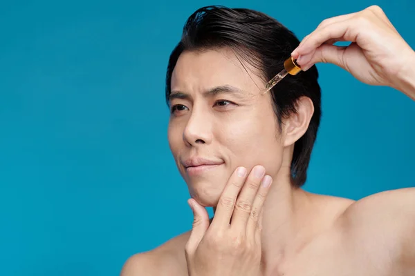 Homem Aplicando Soro Vitamina Rosto Isolado Azul — Fotografia de Stock