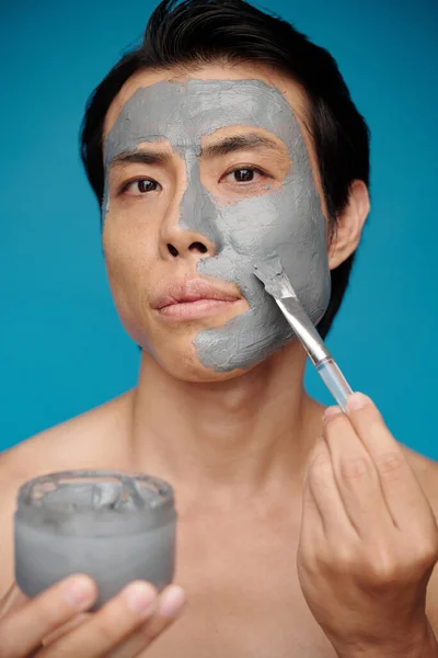 Porträtt Man Tillämpa Renande Lera Mask Ansiktet — Stockfoto