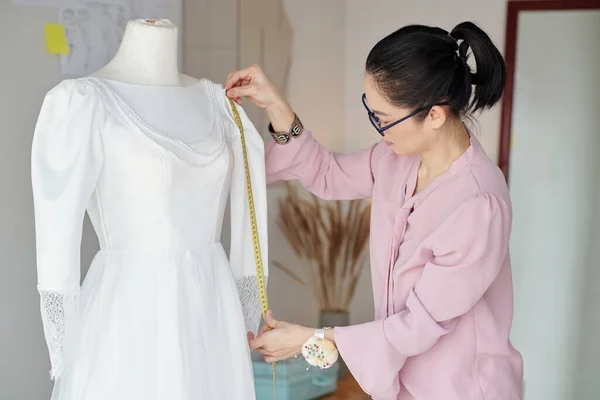 裁缝师在人体模特身上测量白色连衣裙袖子 — 图库照片