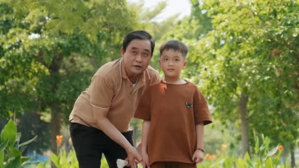Média Tiro Longo Pai Asiático Ensinando Filho Como Jogar Badminton — Vídeo de Stock