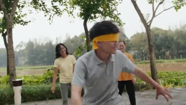 Gözleri Bağlı Asyalı Bir Adamın Parkta Kör Adam Oyunu Oynarken — Stok video