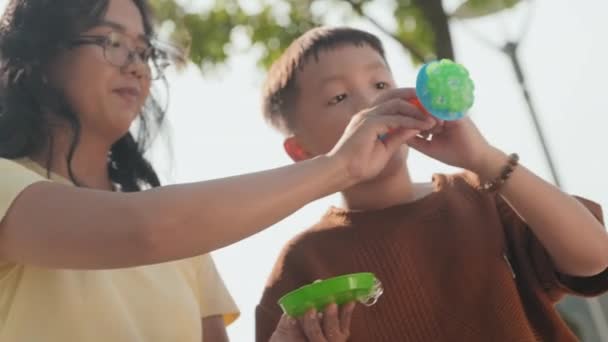 Низкий Угол Съемки Маленький Азиатский Мальчик Дует Мыльные Пузыри Играть — стоковое видео